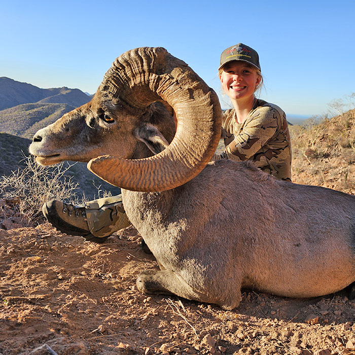 Female hunter with a bighorn sheep